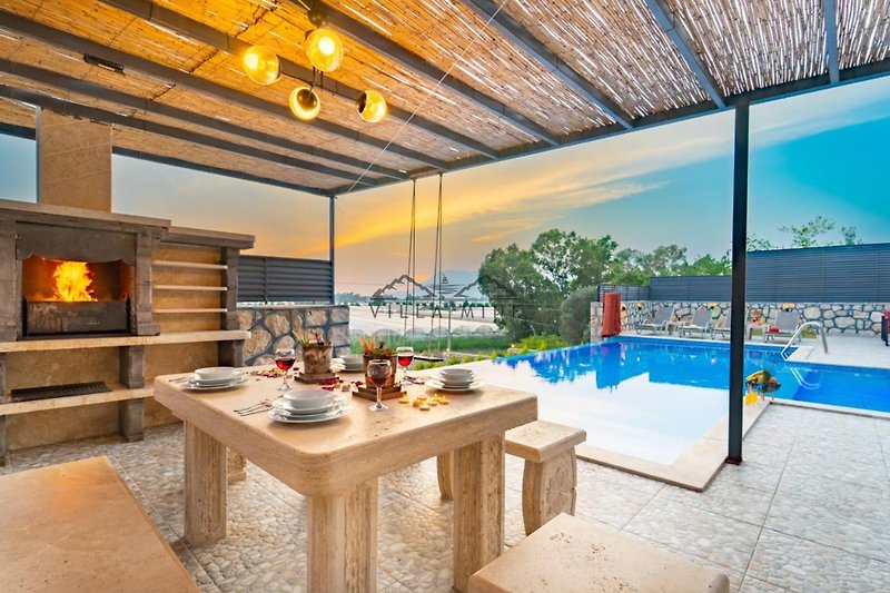Elegantes Wohnzimmer mit Holzmöbeln und Blick auf den Pool.