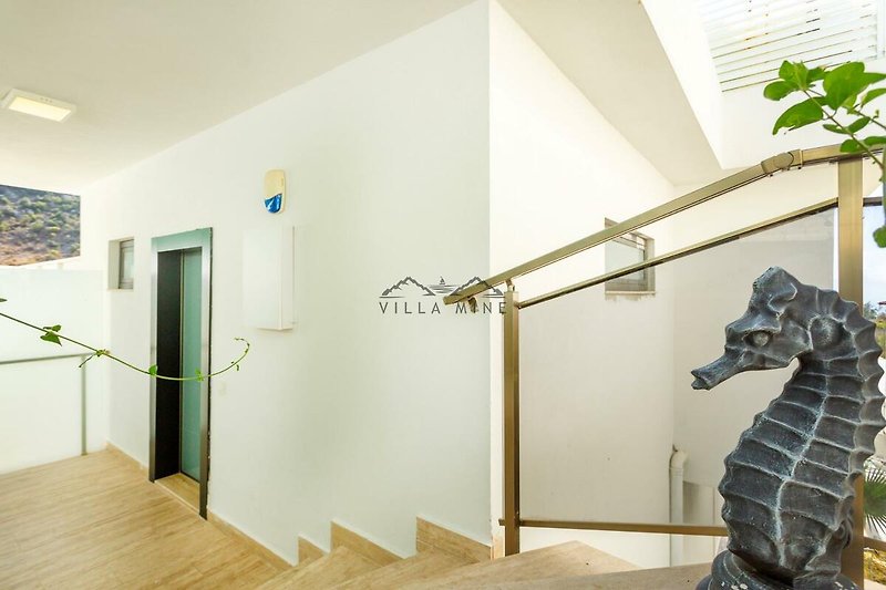 Kunstvolle Treppe mit Giraffen-Skulptur und Holztür.
