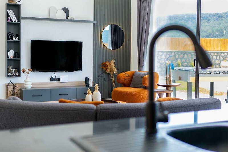 Wohnzimmer mit orange-farbenem Sofa, Holzmöbeln und Dekoration.