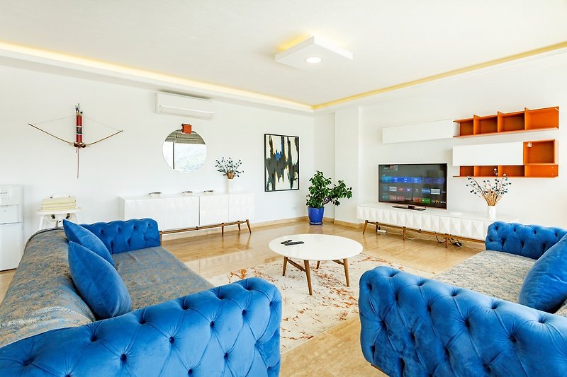 Gemütliches Wohnzimmer mit blauer Couch, Holzmöbeln und gemütlicher Einrichtung.