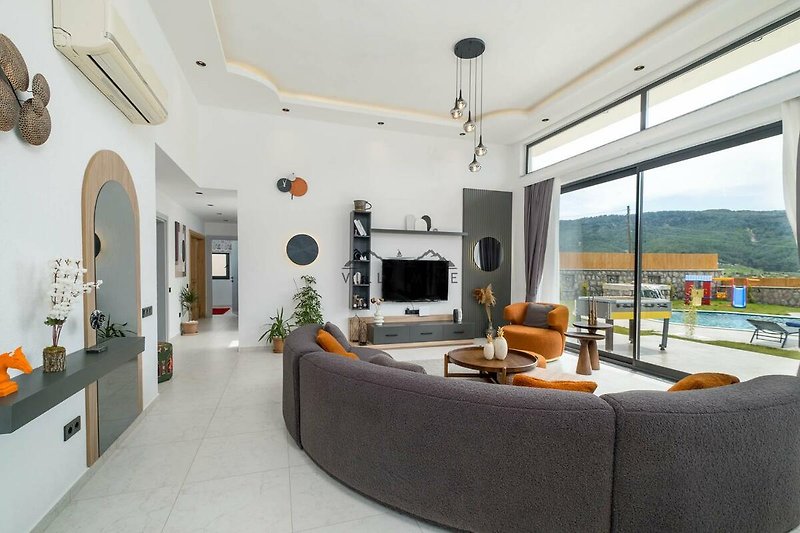 Wohnzimmer mit orange-farbenem Sofa, Holzmöbeln und Fernseher.