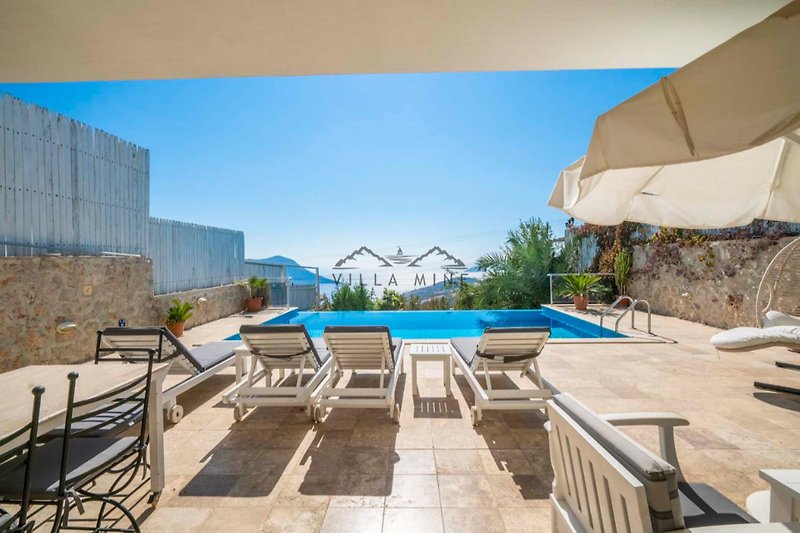 Luxuriöses Apartment mit Pool, Sonnenliegen und urbanem Design.