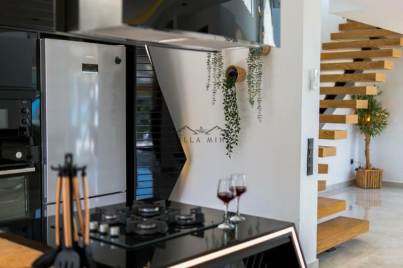Moderne Küche mit Gasherd, Küchengeräten und Holzboden. Ideal zum Kochen!