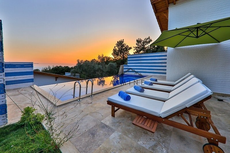 Schönes Haus mit Pool, Sonnenliegen und Blick auf das Meer.
