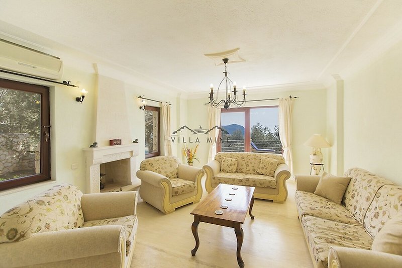 Wohnzimmer mit stilvoller Einrichtung, gemütlicher Couch und dekorativer Pflanze.