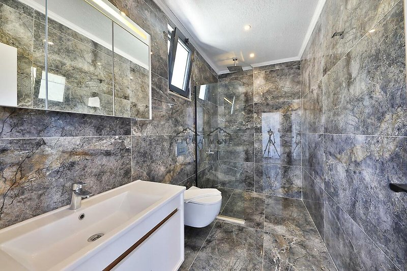 Modernes Badezimmer mit Spiegel, Badewanne und Fliesenwand.