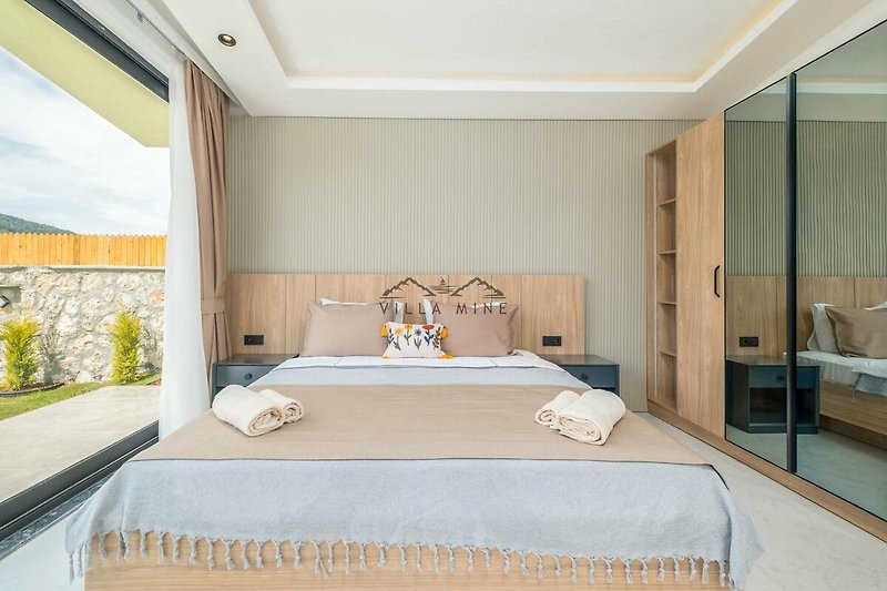 Modernes Schlafzimmer mit elegantem Bett, stilvoller Dekoration und Fensterblick.