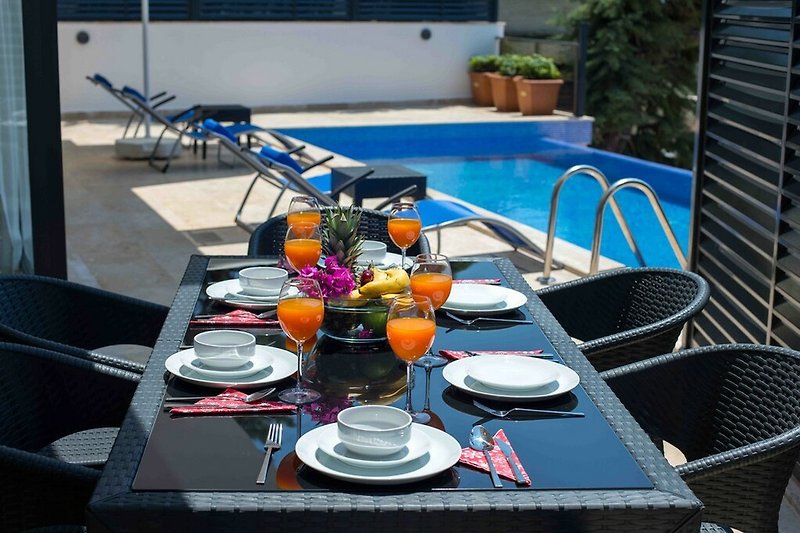 Tisch mit Geschirr, Pflanze, Stühle, Pool, Blumen - perfekt für Mahlzeiten im Freien!