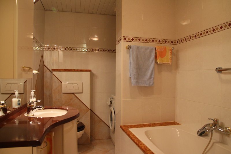 Badkamer met ligbad, douche en toilet