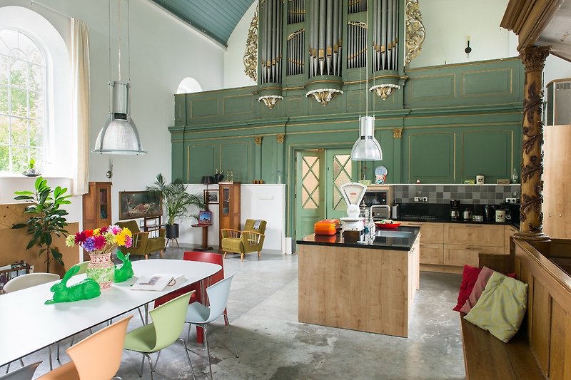 Im alten Kirchensaal befinden sich der moderne Esstisch, die Küche, die Kanzel, die Herrenbank, die Orgel und 2 Sitzecke