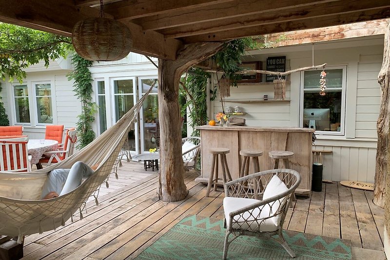 Holzterrasse mit Pflanzen und Outdoor-Möbeln.
