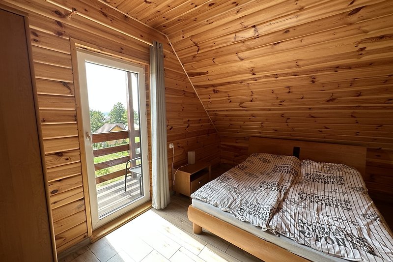 Sypialnia z wygodnym łóżkiem i naturalnym drewnem.