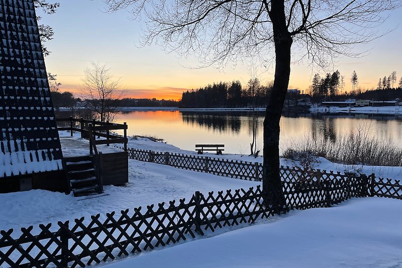Ein idyllischer Sonnenuntergang über einem gefrorenen See.