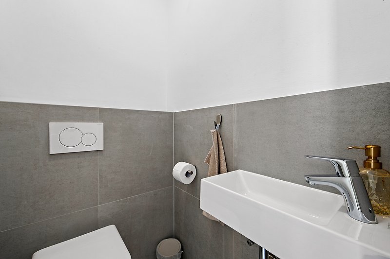 Stilvolles Badezimmer mit modernem Waschbecken und Holzwand.