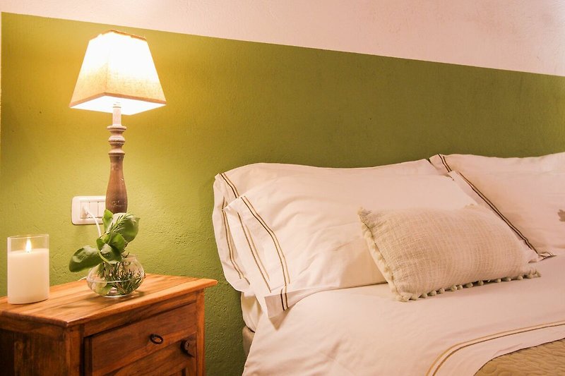 Affitto appartamento con arredamento in legno e lampada. Rilassati nella comoda camera da letto.