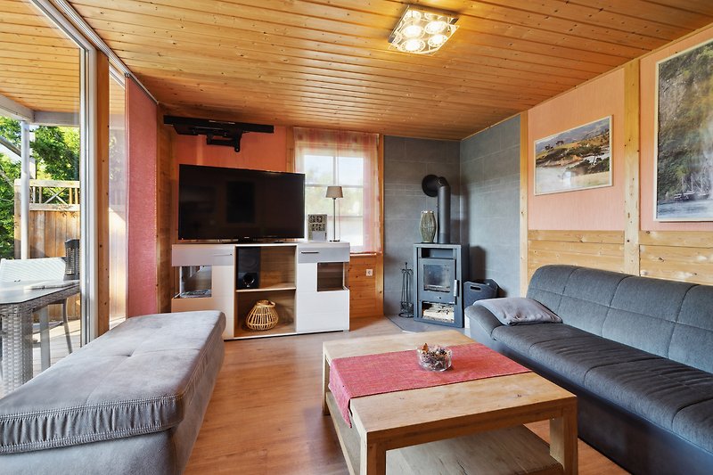 Gemütliche Ferienwohnung mit stilvollem Interieur, Holzbalken und bequemer Couch.