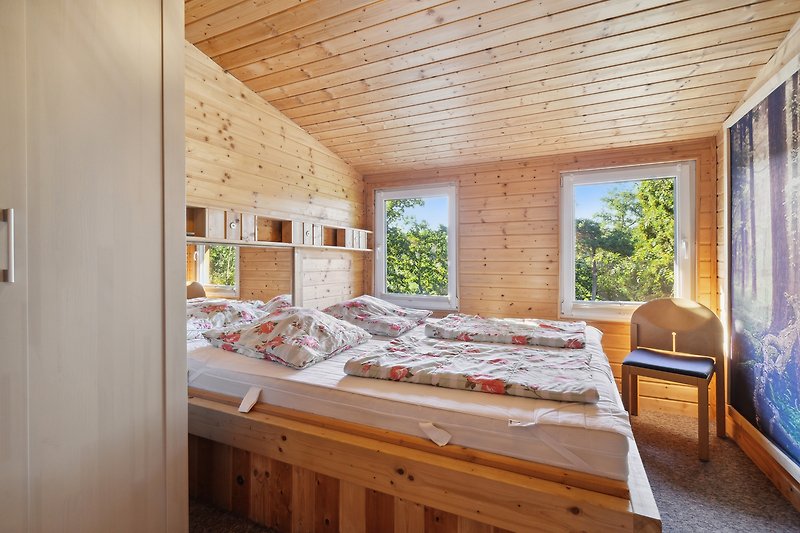 Schlafzimmer mit bequemem Bett und Fenster.