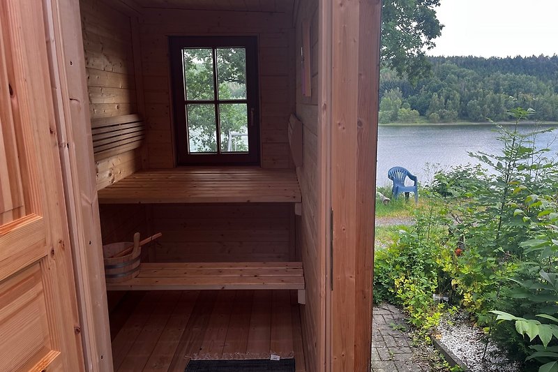 Ferienhaus am See mit Holzverkleidung und schöner Aussicht.