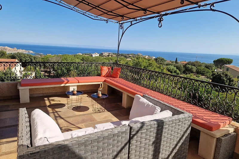 Casa con giardino, terrazza e mobili da esterno. Vista sulla natura e sull'architettura.