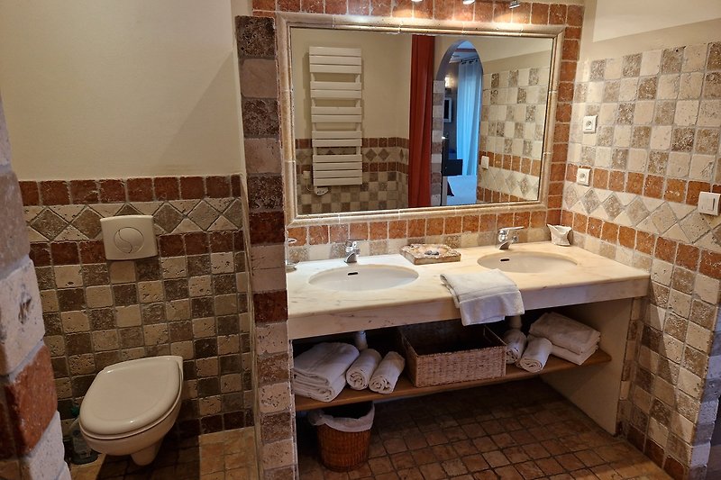 Magnifique salle de bain en bois avec lavabo et robinetterie violette.