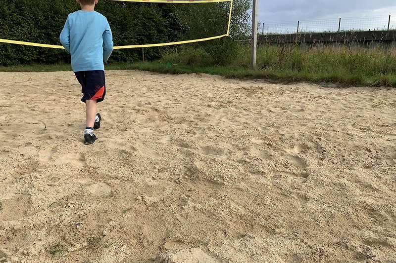 ein eigener Beach-Volleyballplatz mit Netz, Ball und der Option ihn auch einfach nur dafür zu nutzen, im Sand zu liegen