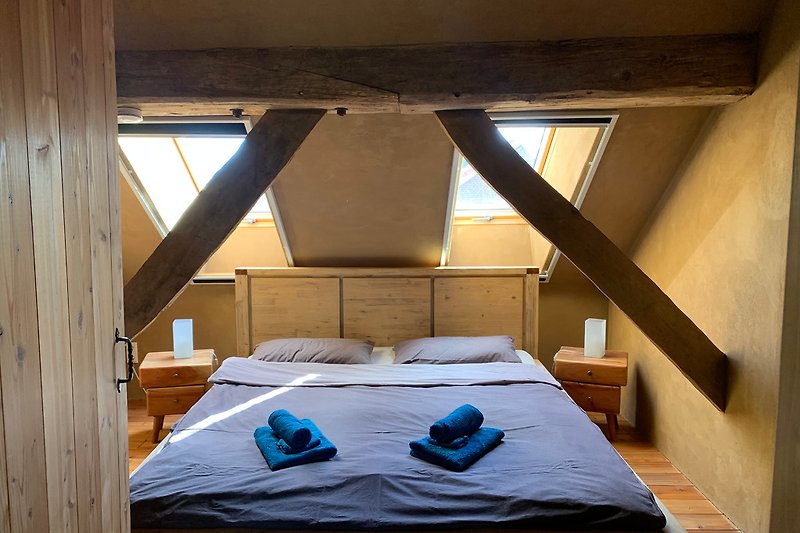 ein Schlafzimmer mit einem 180cm breitem Holzbett