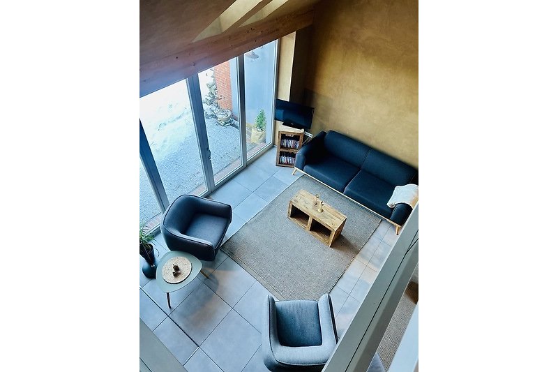 Stilvolles Wohnzimmer mit großem Fenster, bequemer Couch und Pflanzen.