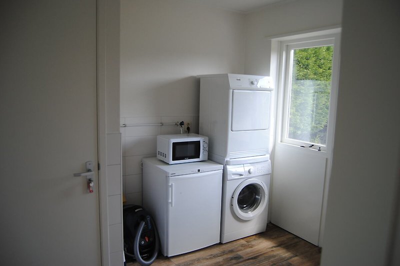 Gewirrschafsraum mit Waschmaschine, Trockner, Mikrowelle und Gefrierschrank