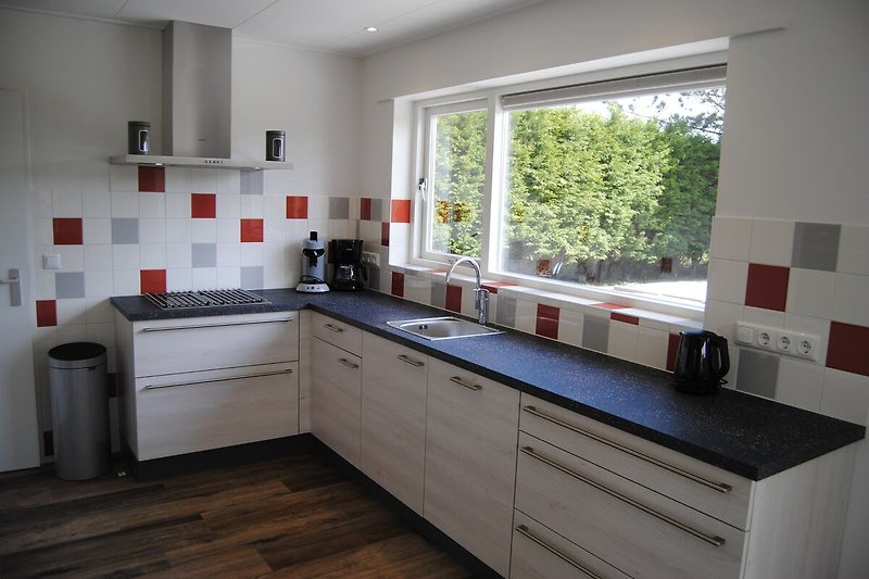 Moderne Küche mit Holzelementen, Granit-Arbeitsplatte und Fenster.