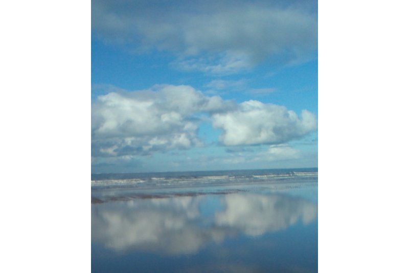An der Nordsee: Wasser spiegelt Wolken
