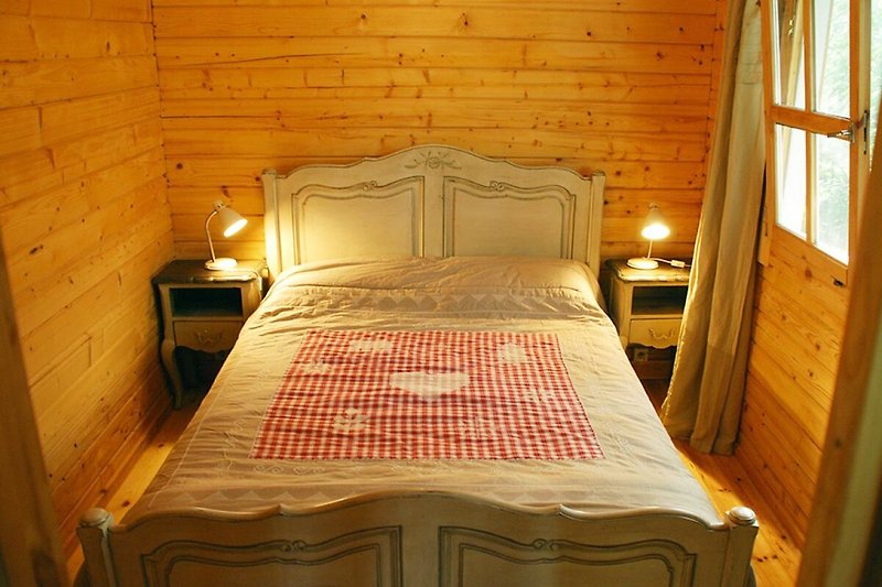 Gemütliches Schlafzimmer mit Holzbett, Lampen und stilvollem Interieur.