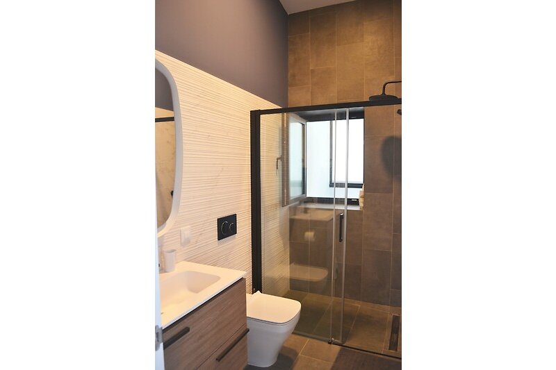 Modernes Badezimmer mit Holzdetails und rechteckigem Spiegel.