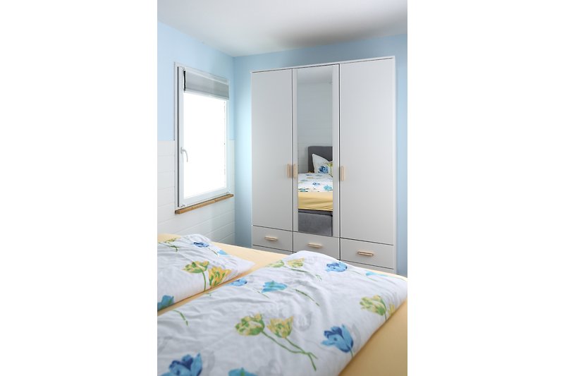 Schlafzimmer mit Doppelbett und Spiegelschrank