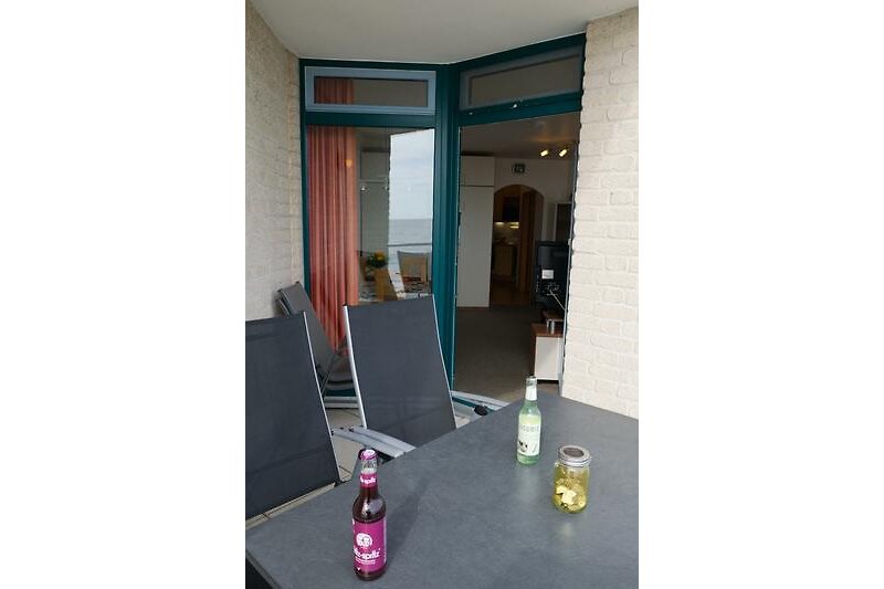 Blick vom Balkon ins Wohnzimmer der Ferienwohnung Inselblume 03 auf Fehmarn