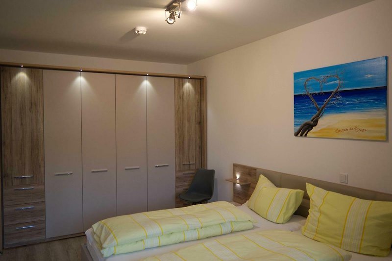 Doppelbett mit grosser Schrankwand im Schlafzimmer der Fewo auf Fehmarn