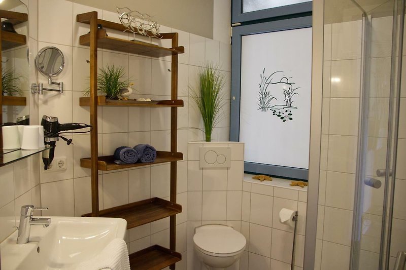 Badezimmer mit Regal in der Ferienwohnung Inselblume 48 in Burgtiefe auf Fehmarn