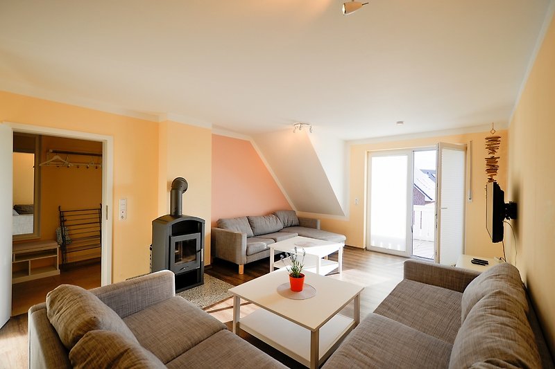 Couch mit Kamin und Balkon in dem Ferienhaus für 12 Personen auf Fehmarn
