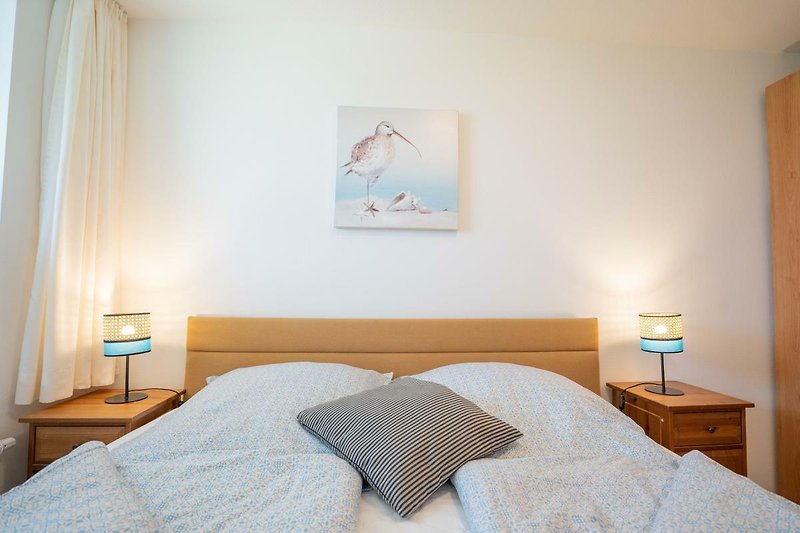 Doppelbett mit Nachttischen im Schlafzimmer der Ferienwohnung Inselblume 56