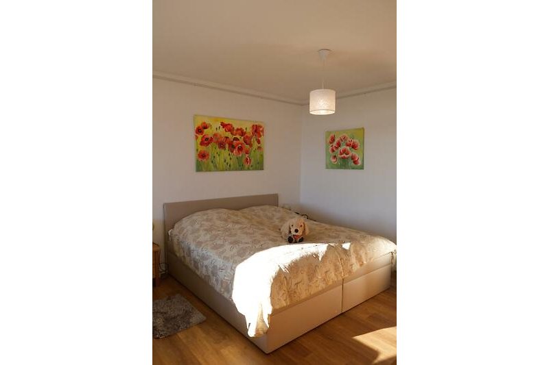 Doppelbett im Wohnzimmer der Ferienwohnung für 4 Personen