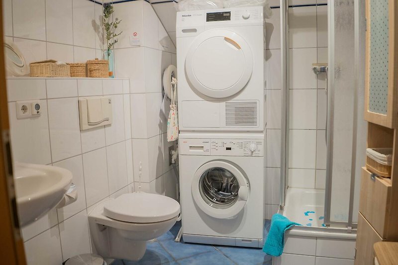 Badezimmer mit Waschmaschine und Trocker in der Ferienwohnung in der Strandburg