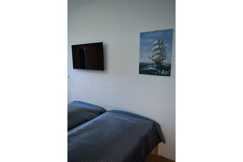 Schlafzimmer mit TV in der Ferienwohnung direkt am Südstrand