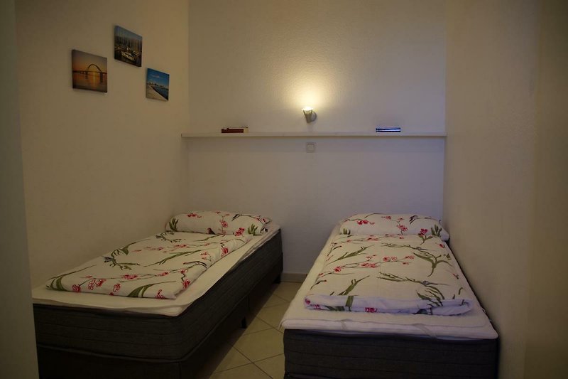 Einzelbetten im Schlafzimmer der Ferienwohnung Inselblume 45 für 4 Personen am Strand von Fehmarn