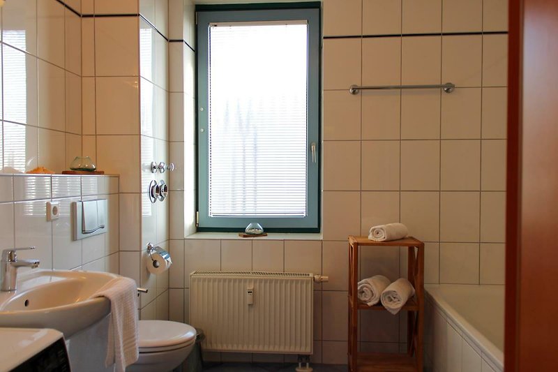 Geräumiges Badezimmer mit WC, Waschbecken, Dusche und Badewanne in der Inselblume 55 auf Fehmarn