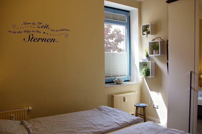 Anderer Blick aufs Doppelbett im Schlafzimmer der Ferienwohnung Inselblume 48 auf Fehmarn