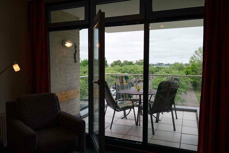 Blick auf den Balkon aus dem Wohnzimmer der Ferienwohnung für 4 Personen auf Fehmarn