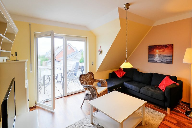 Wohnzimmer mit Couch und Balkon in der Ferienwohnung für 8 Personen in Burg auf Fehmarn