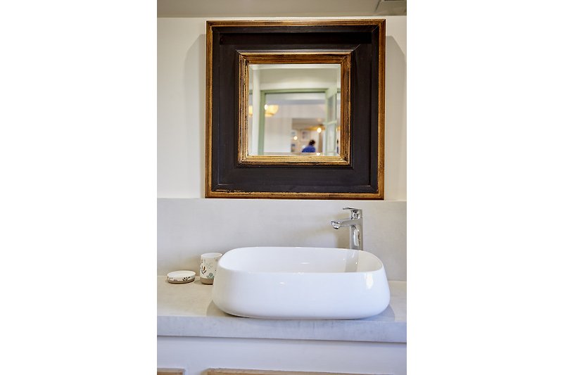 Miroir brun avec robinet dans une salle de bain en bois.