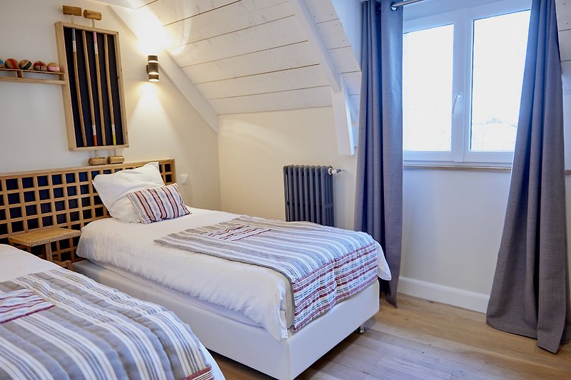 Intérieur confortable avec un lit en bois et des rideaux élégants.
