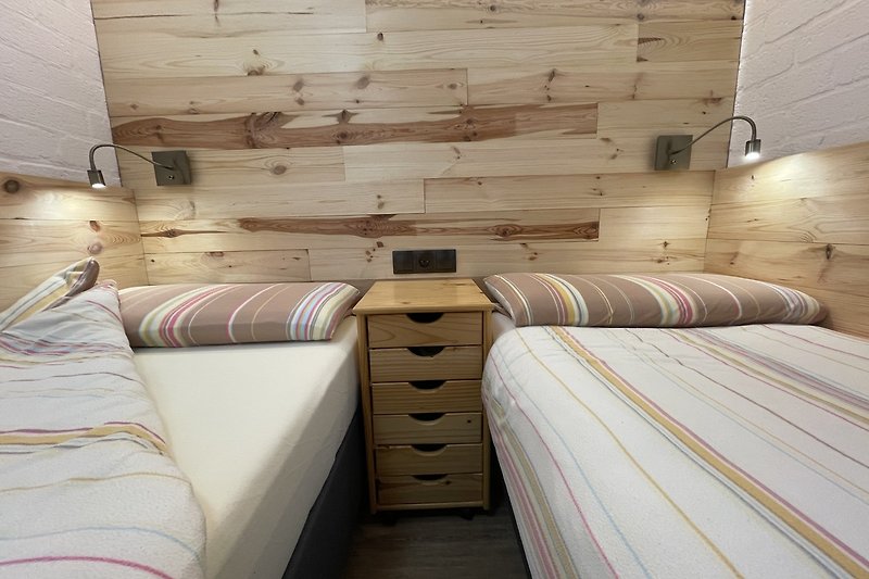 Gemütliches Schlafzimmer mit stilvollem Holzinterieur (Wandverkleidung mit Echtholz).