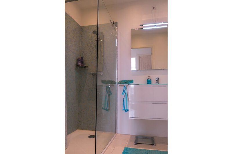 Mooie badkamer met moderne douche en glazen douchewand.